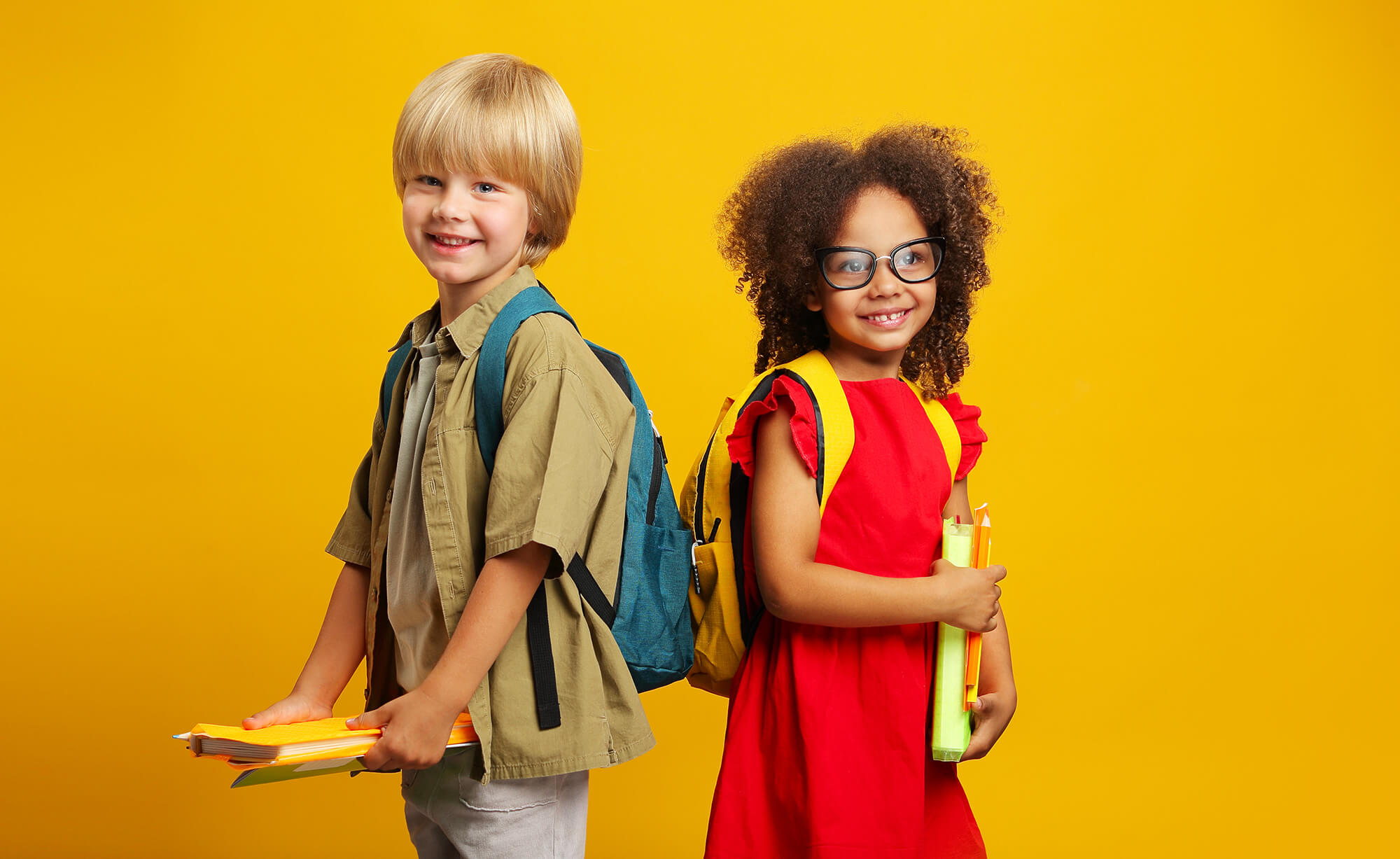 Two kids with backpacks on a yellow background
